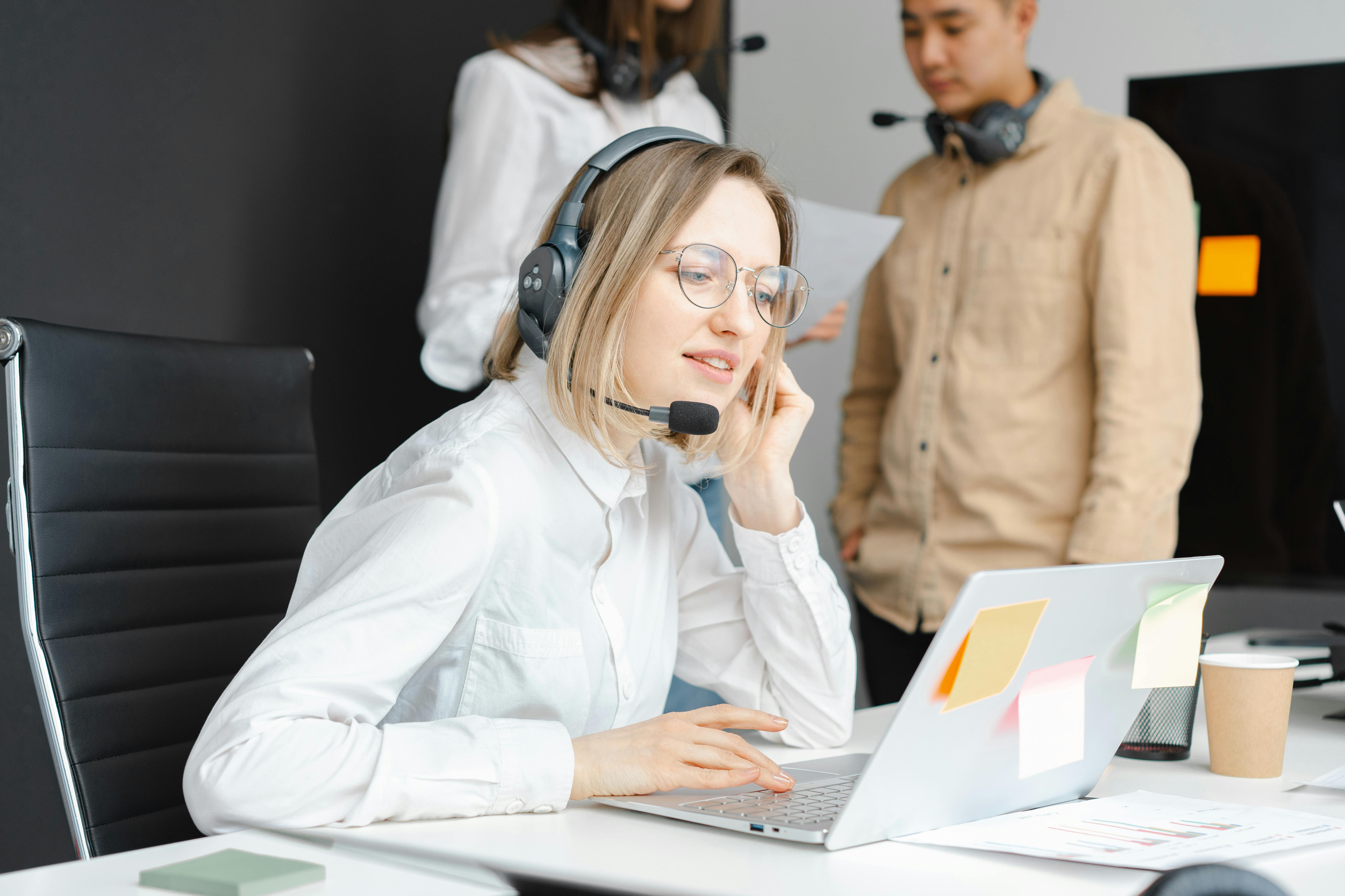 Kundenbetreuerin mit Headset im Beratungsgespräch am Laptop